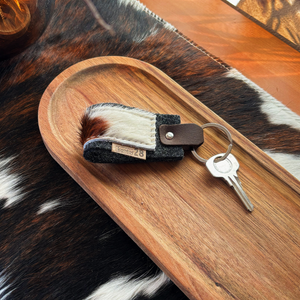 Schlüsselanhänger mit Fell auf einem Deko-Holz auf einem Tischläufer aus Kuhfell
