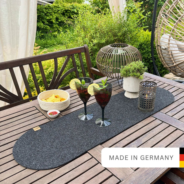 Tischläufer anthrazit aus Filz nachhaltig Made in Germany mit Rundung an beiden Seiten auf einem Holtzisch im Garten