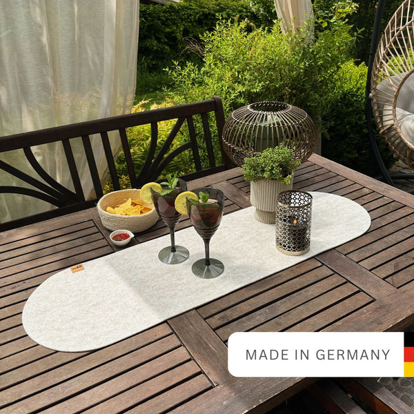 Beiger Tischläufer aus Filz nachhaltig Made in Germany mit Rundung an beiden Seiten auf einem Holtzisch im Garten