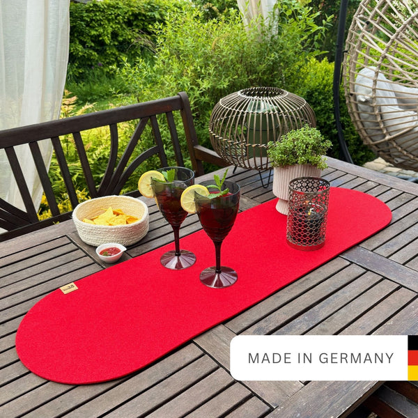 Tischläufer rot aus Filz nachhaltig Made in Germany mit Rundung an beiden Seiten auf einem Holztisch im Garten