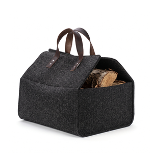 Anthrazitfarbene Kaminholztasche aus Filz mit Ledergriffen, gefüllt mit Brennholz als moderner Holzkorb für Kamin und Wohnzimmer
