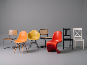 Verschiedene Stuhlmodelle und Designklassiker im Vergleich – darunter Eames Sidechair, Eames Armchair, Thonet Freischwinger, Panton Chair sowie IKEA Holzstühle in Schwarz und Weiß.