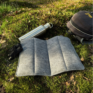 sitzkissen faltbar outdoor in grau auf einem waldboden zum wandern