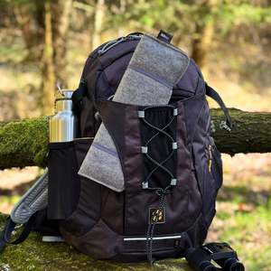 sitzunterlage outdoor verstaut in einem rucksack im wald