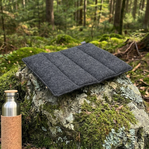 wandern sitzkissen in anthrazit auf einem stein im wald
